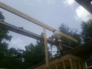 Carpenter setting a ridge beam over a new addition frame — Ice Dam Removal by Roofing Brothers in Mccordsville