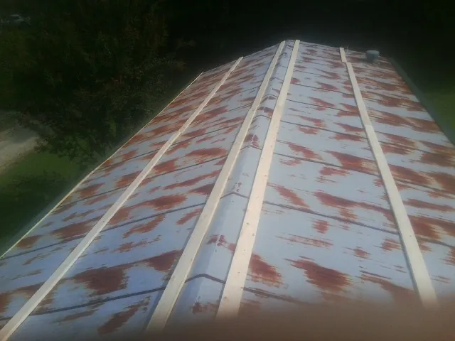 Rusted metal roof panels with new wood purlins before replacement — Storm Damage Roof Repair in Mccordsville by Roofing Brothers