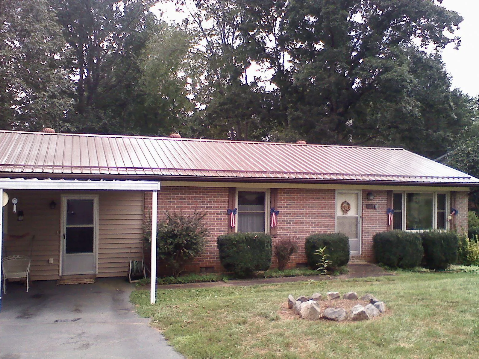 Bronze metal roof and carport on a brick ranch home — Roof Repair work by our crew in Mccordsville